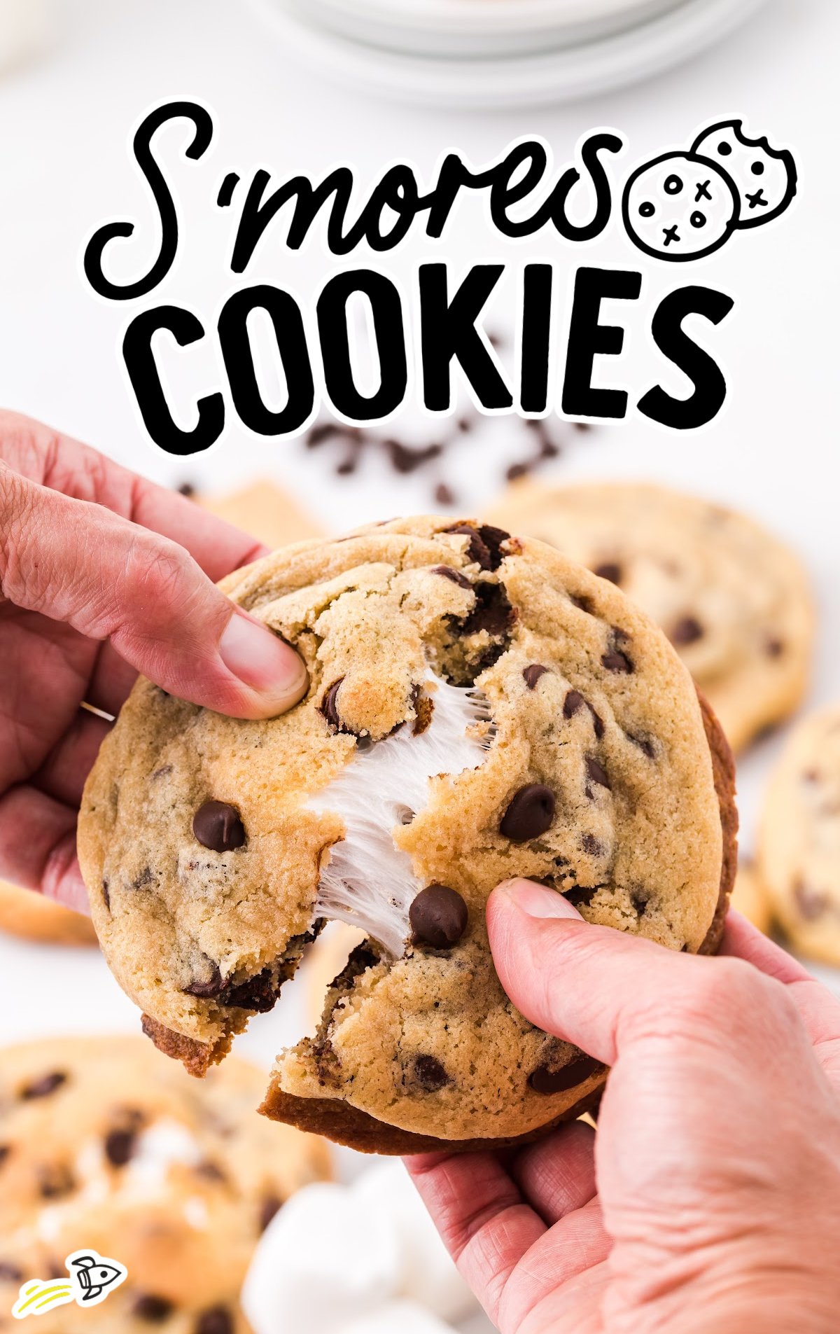 A person is pulling apart a S'mores Cookie to reveal the gooey inside. 