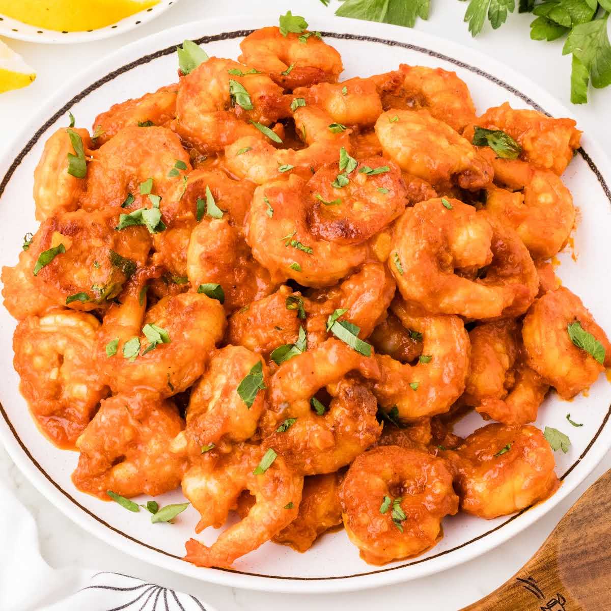 Square image of spicy garlic shrimp plated and garnished, ideal for a recipe card or social preview.