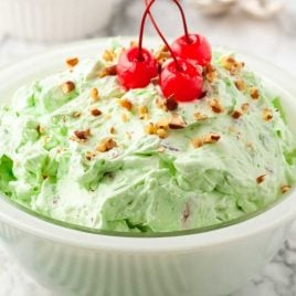 close up shot of Watergate salad topped with walnuts and cherries
