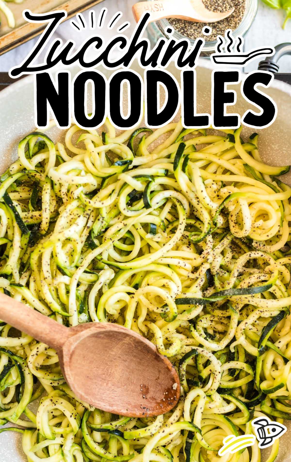 close up shot of Zucchini Noodles in a bowl with a wooden spoon