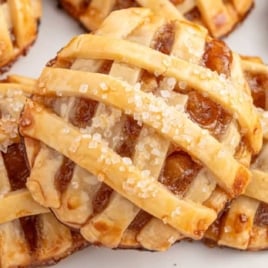 Plate of baked apple pie cookies with lattice tops, sprinkled with coarse sugar.