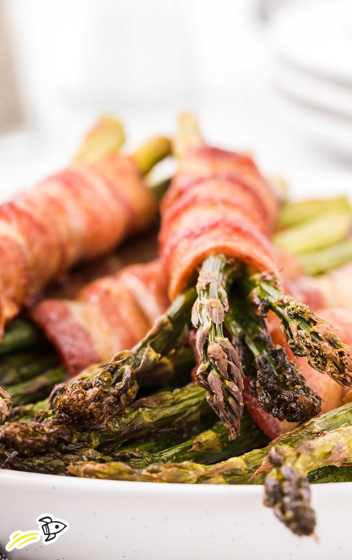 close up shot of bacon wrapped asparagus on a plate