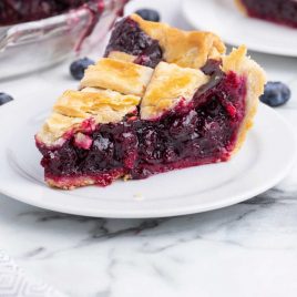 close up shot of a slice of blueberry pie on a plate