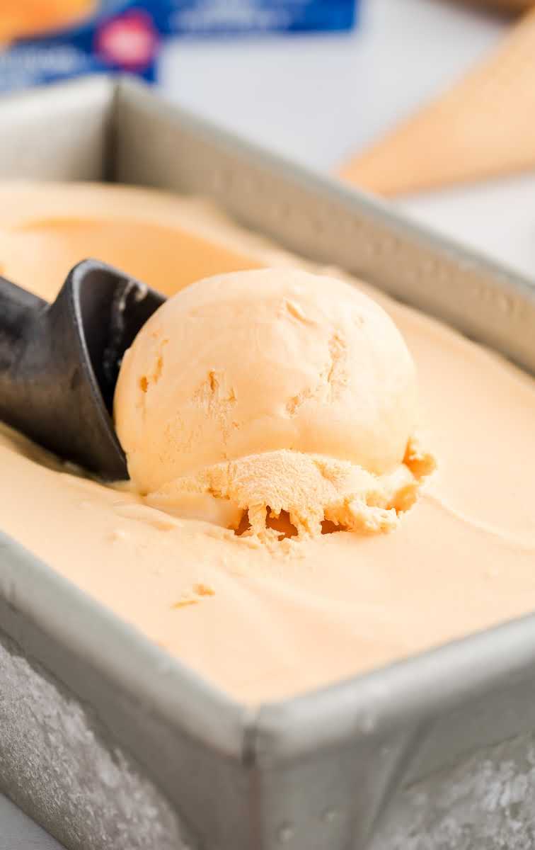 close up shot of cheese ice cream being scooped up with a ice cream scooper