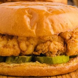 close up shot of fried chicken sandwich on a wooden board