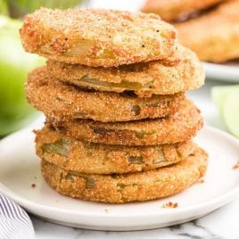 close up shot of fried green tomatoes stacked on top of each other on a plate