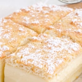 Baking pan of sliced magic custard cake topped with powdered sugar, with text “How to Make Magic Custard Cake — Full of Tips & Hints.”