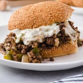 close up shot of philly cheesesteak sloppy joes with provolone and green peppers on buns