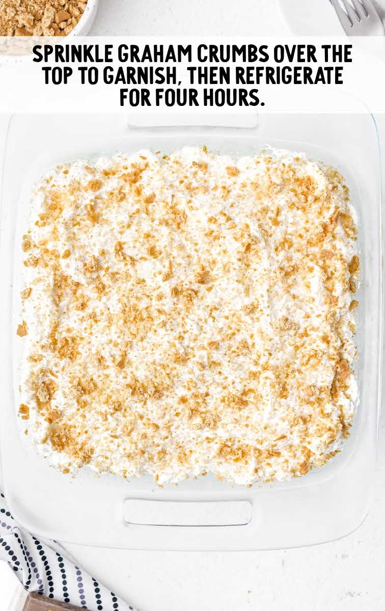 pineapple delight process shot of graham cracker crumbs being spread on top of cake