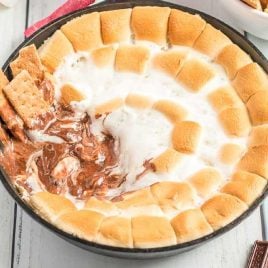 close up shot of a pan of s'mores dip with graham crackers
