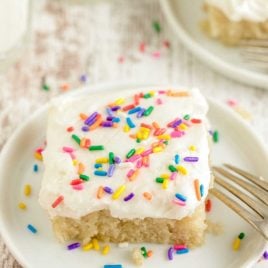 close up shot of a slice of vanilla crazy cake topped with sprinkles on a plate