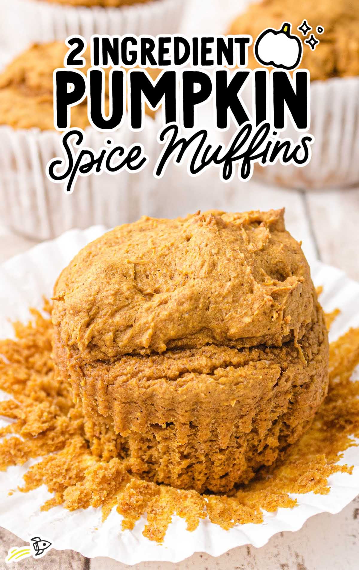 Pumpkin spice muffin unwrapped in paper liner with text overlay reading “2 ingredient pumpkin spice muffins.”
