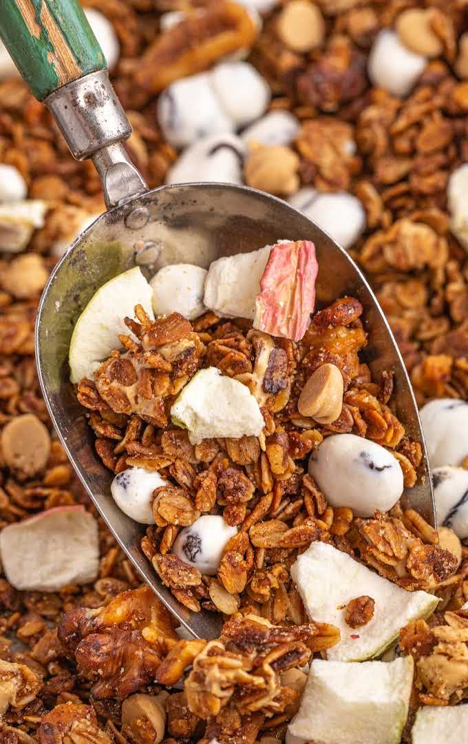 close up shot of apple cinnamon granola being scooped up with a spoon
