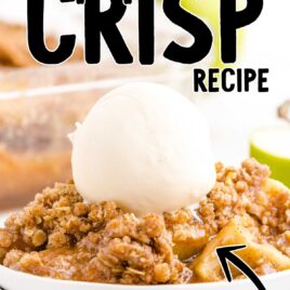 close up shot of a serving of apple crisp topped with a scoop of vanilla ice cream on a plate