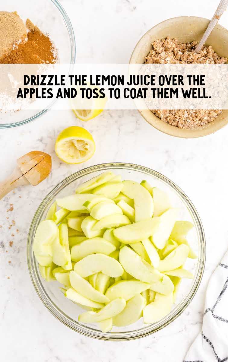 apple crisp process shot of lemon juice drizzled over apples in a bowl