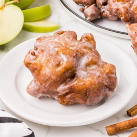 A bunch of food on a plate, with Apple and Fritter