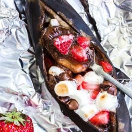 close up shot of campfire banana boats with a spoon on aluminum foil