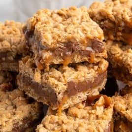 Pile of cut Carmelitas bars showing gooey caramel, chocolate chips, and oat crumble topping.