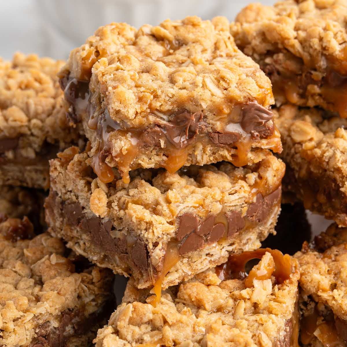 Pile of cut Carmelitas bars showing gooey caramel, chocolate chips, and oat crumble topping.