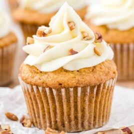 close up shot of a cupcake topped with frosting and pecans