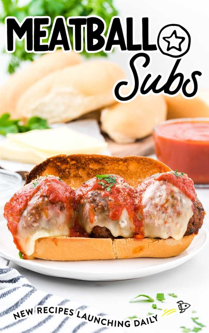 meatball subs topped with mozzarella cheese, tomato sauce, and parsley served on a plate