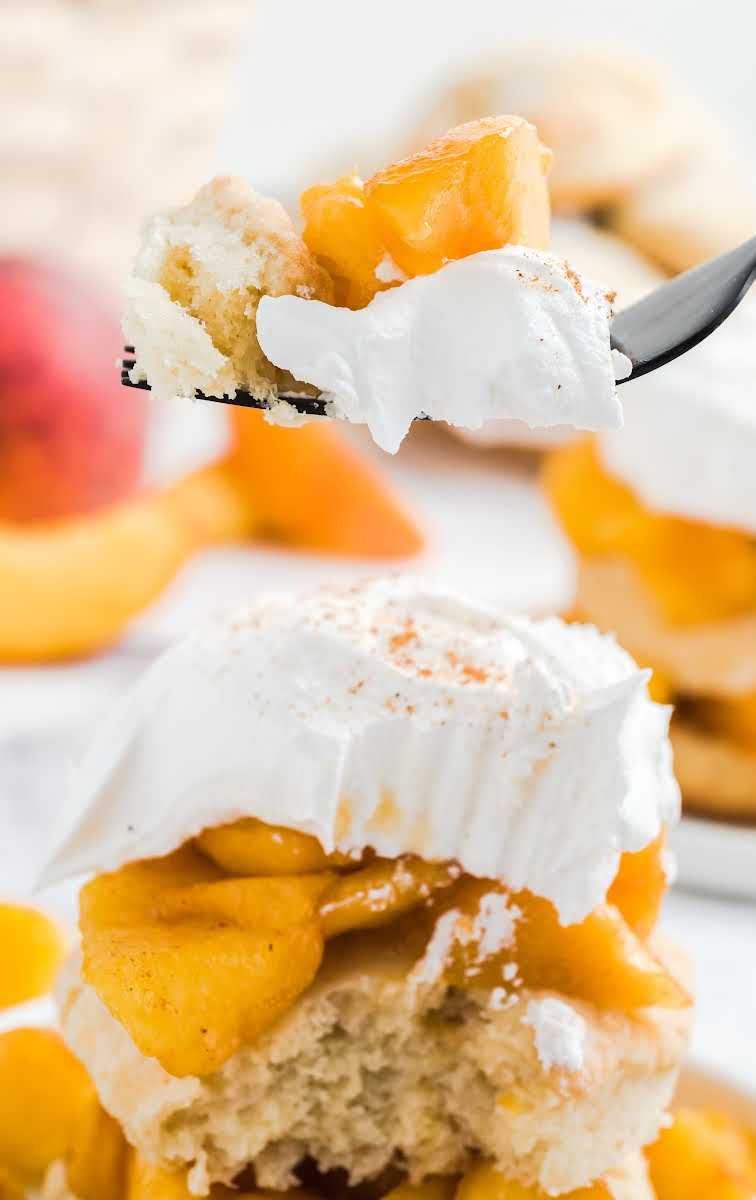 close up shot of Peach Shortcake with a piece of it taken out of it with a fork