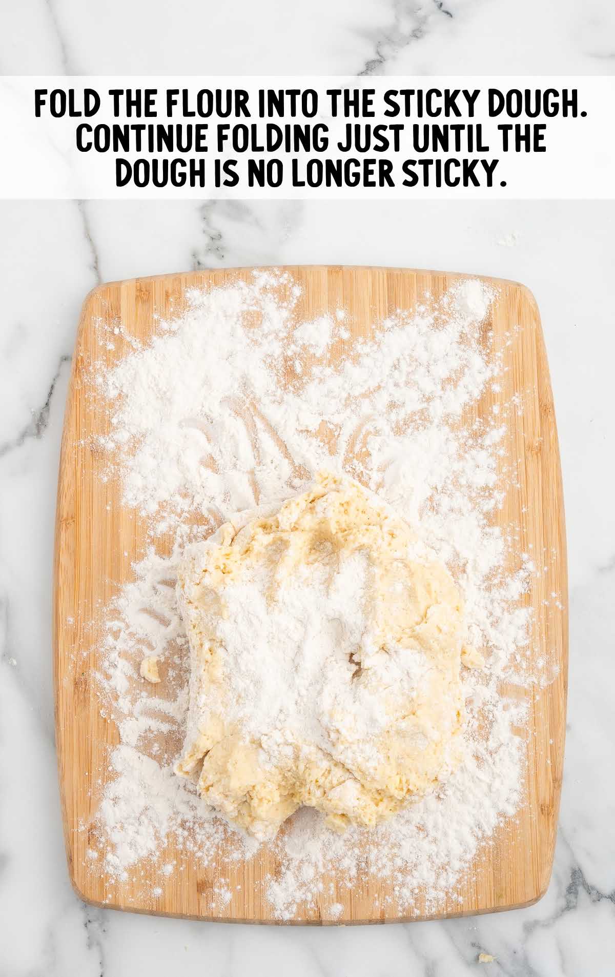 flour rolled into the sticky dough on a wooden board