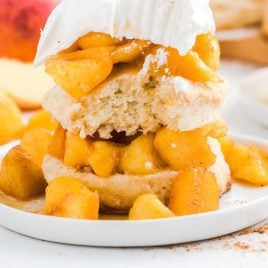 close up shot of Peach Shortcake with a bite taken out of it on a plate