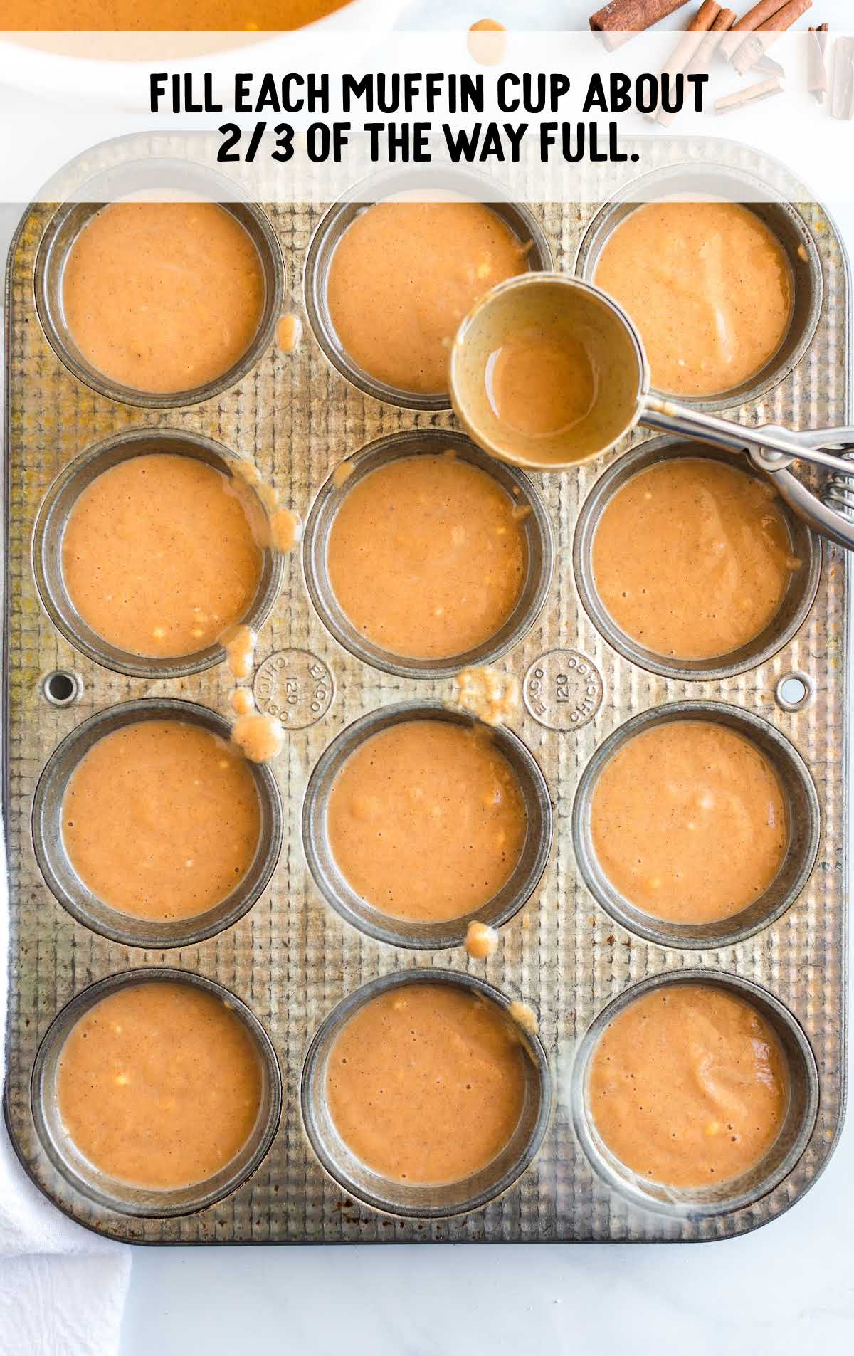 muffin pan being filled with cupcake filling