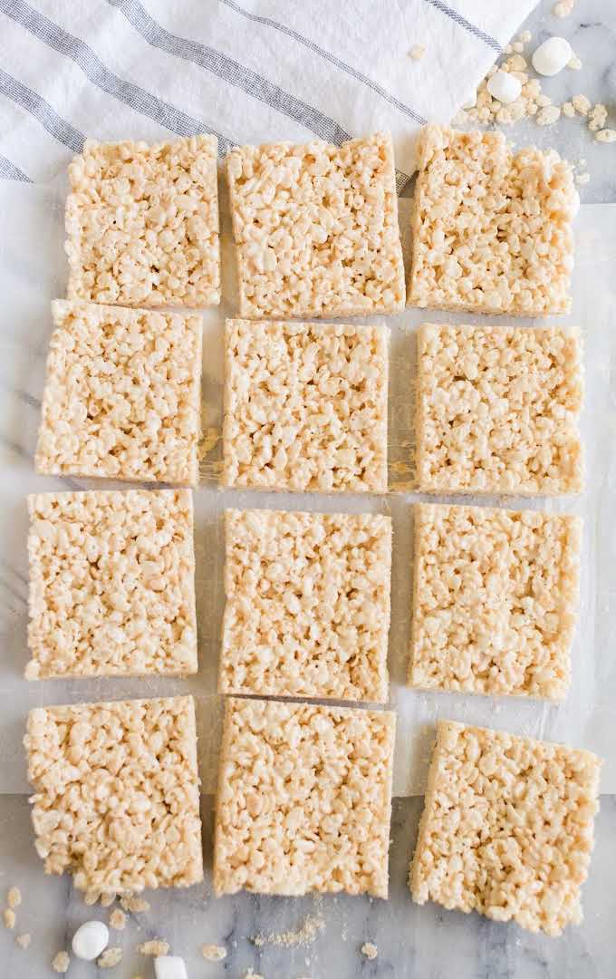 close up overhead shot of Rice Krispie Treats lined on top of parchment paper