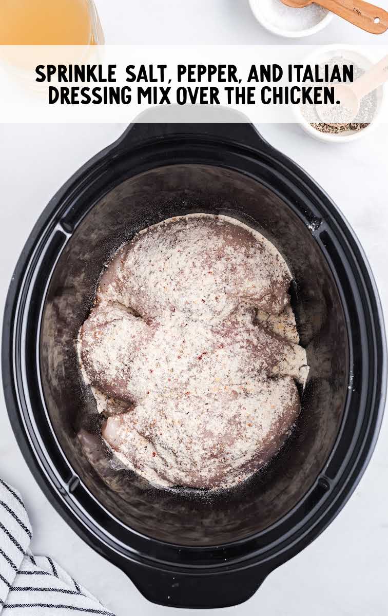 chicken being seasoned in a crockpot