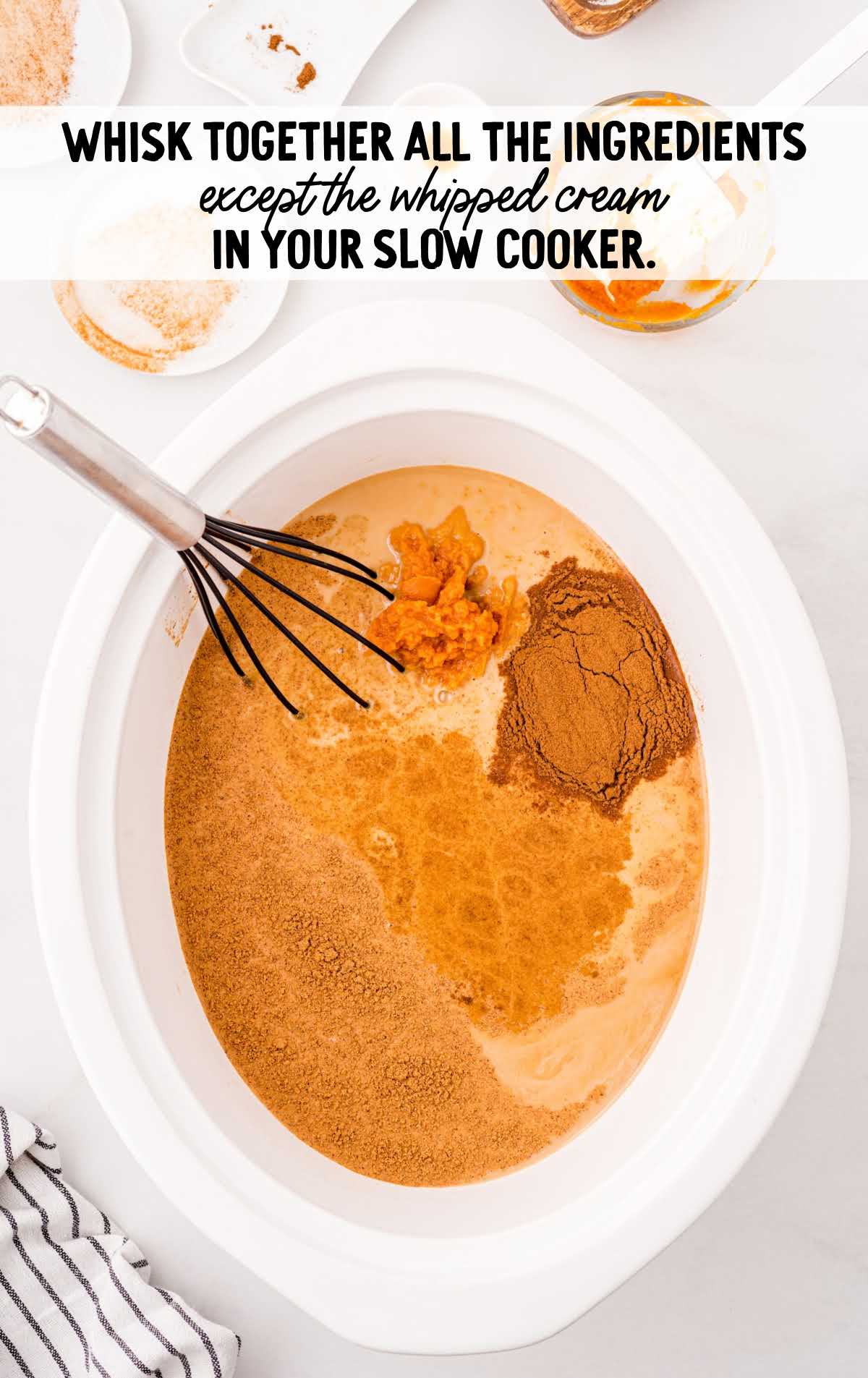 Slow cooker filled with pumpkin spice latte ingredients before mixing.
