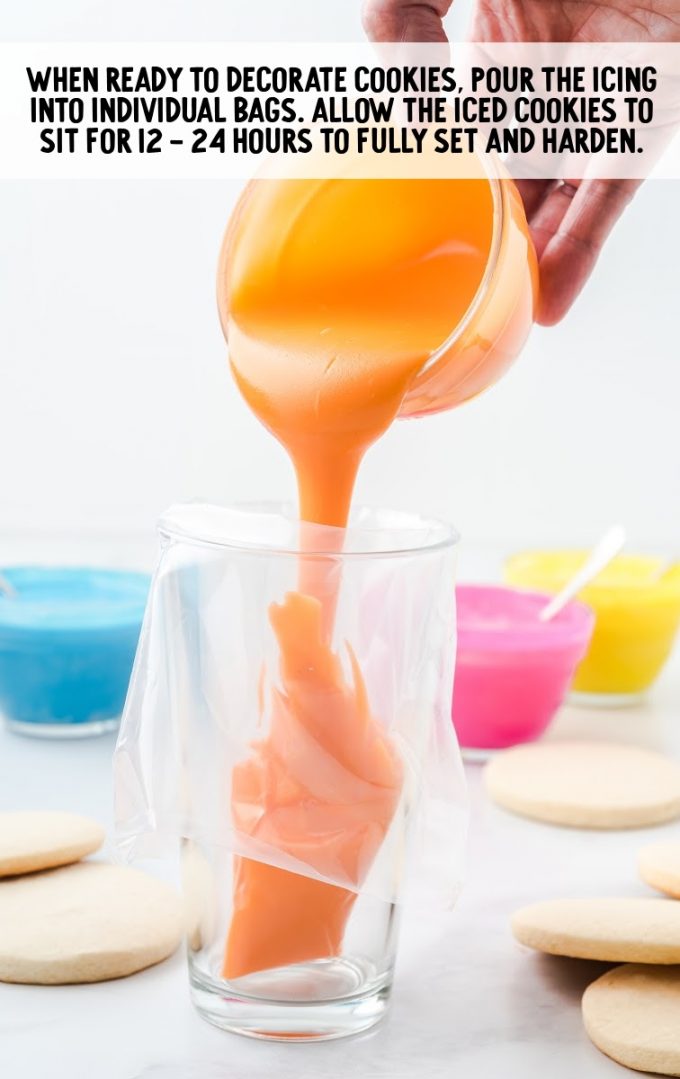 glass with a piping bag inside and orange colored icing being poured in