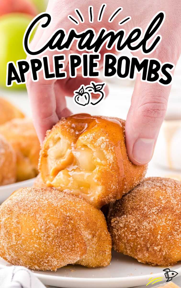 close up shot of caramel apple pie bombs piled on a plate with a caramel apple pie bomb being picked up