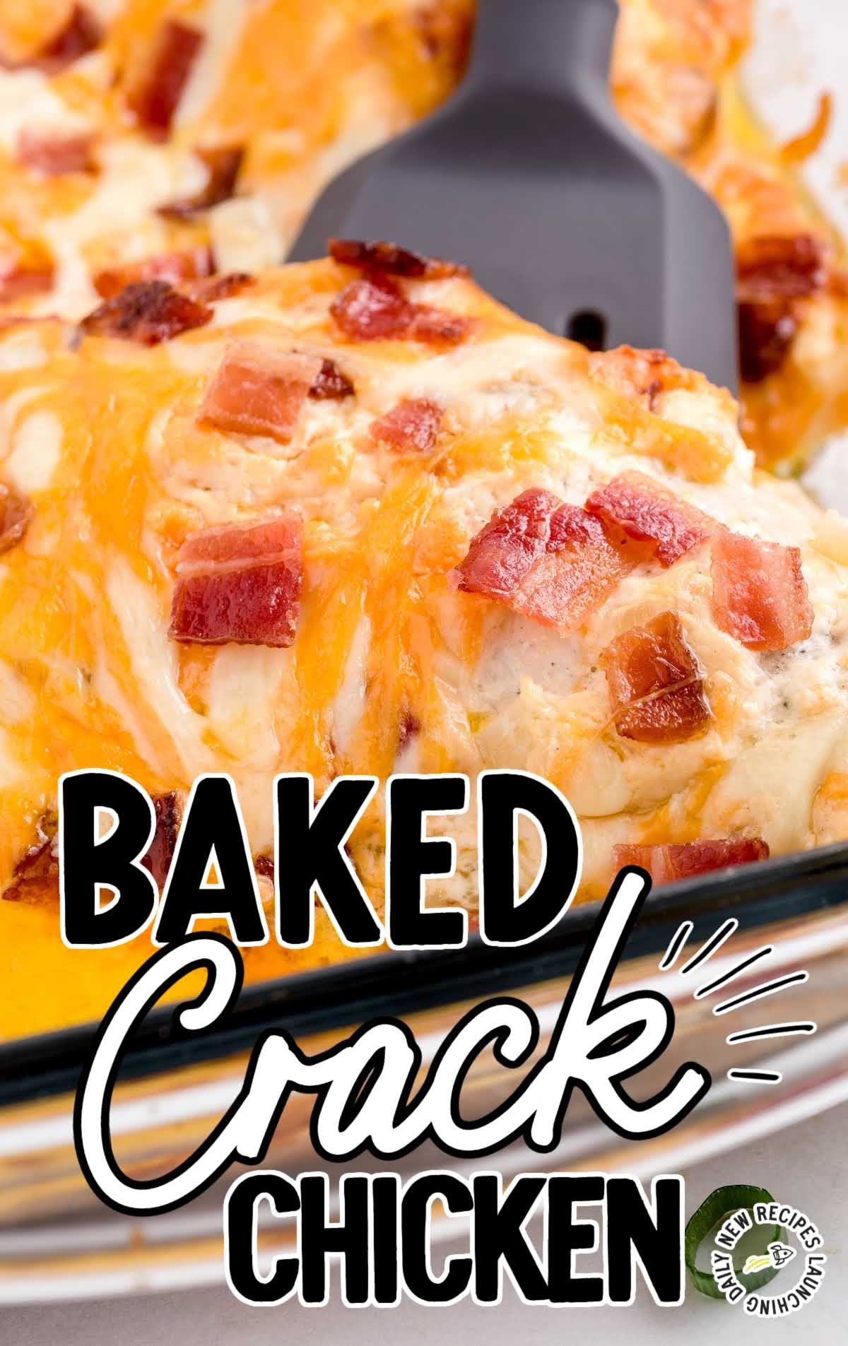 Close-up of cheesy baked crack chicken topped with crispy bacon pieces being lifted from a baking dish.