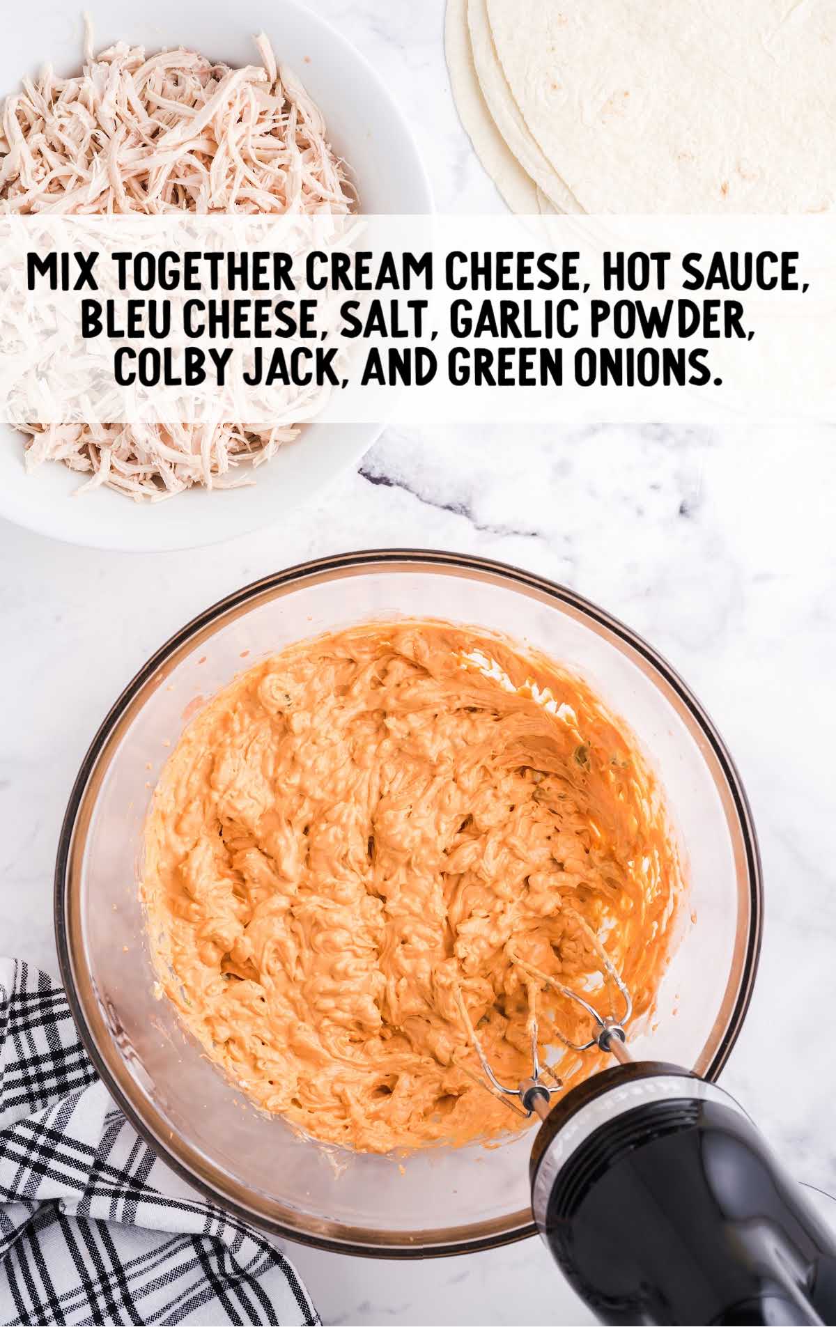 cream cheese, hot sauce, blue cheese, salt, garlic, powder, colby jack, and onions blended together in a bowl