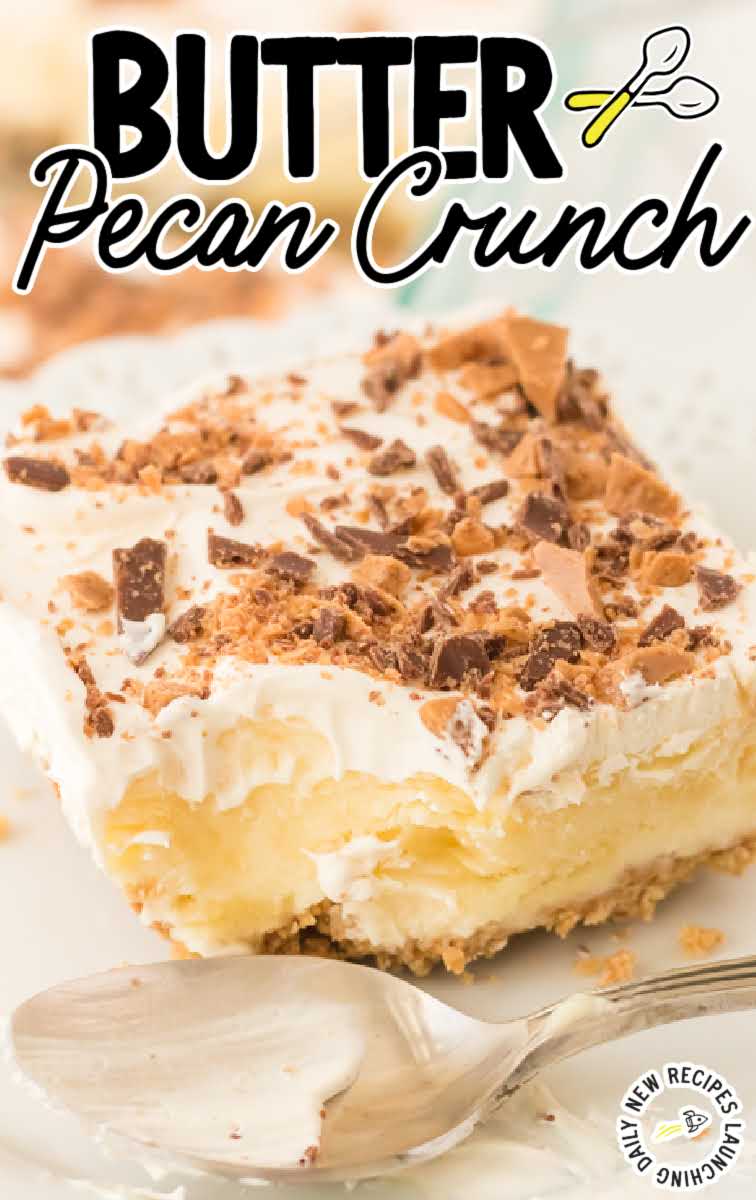 close up shot of a slice of butter pecan crunch topped with cool whip and crumbled heath candy bars on a plate