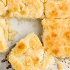 close up overhead shot of Butter Swim Biscuits with a biscuit being picked up with a spatula