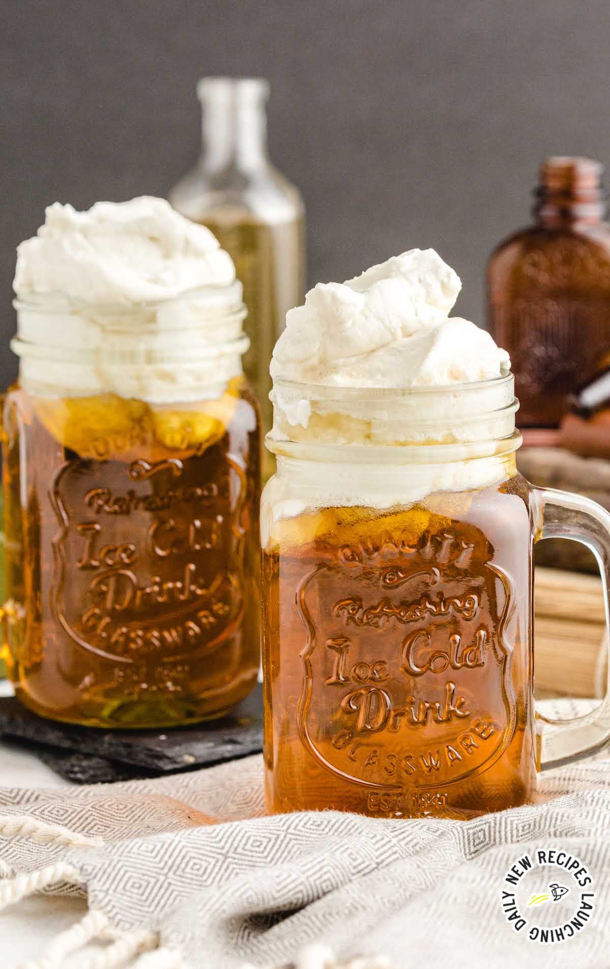 close up shot of jugs of Butterbeer topped with butter cream topping