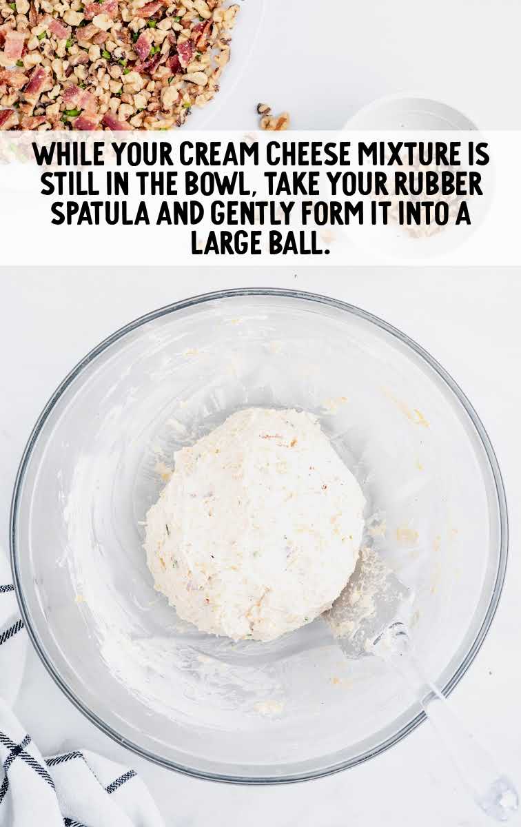 cheese ball recipe process shot of cream cheese mixture being formed into a large ball in a bowl