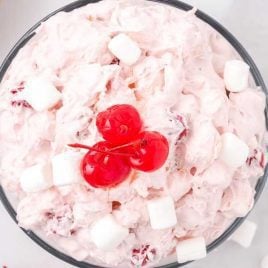 close up overhead shot of Cherry Fluff topped with mini marshmallows and cherries in a large bowl