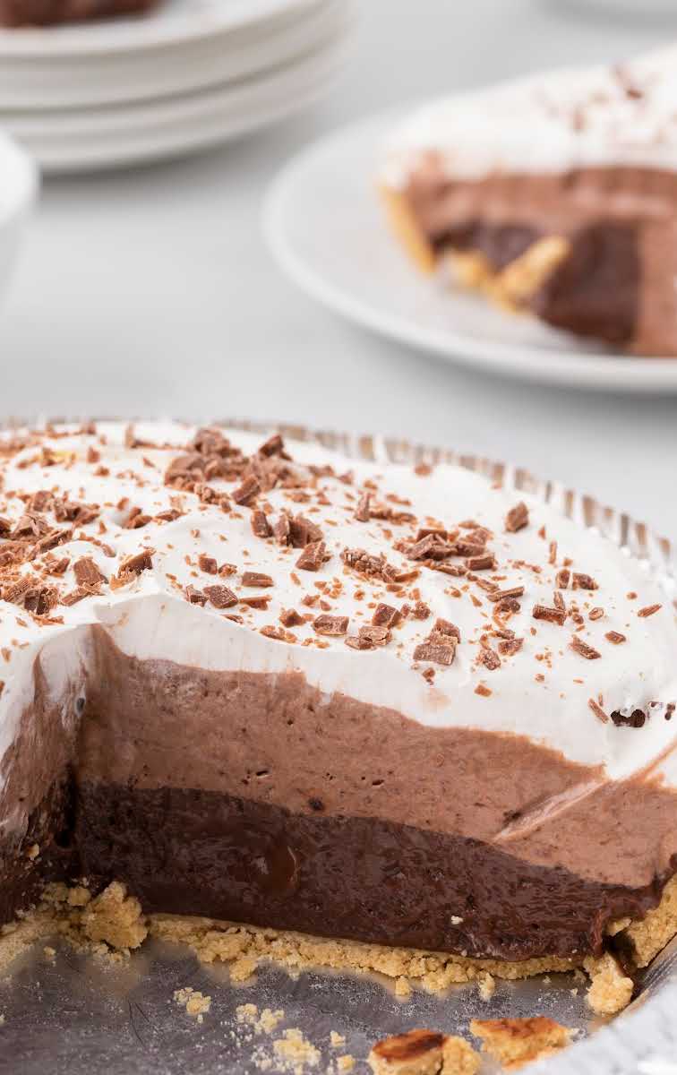 close up shot of chocolate pudding pie garnished with chocolate shavings with a slice of pie missing