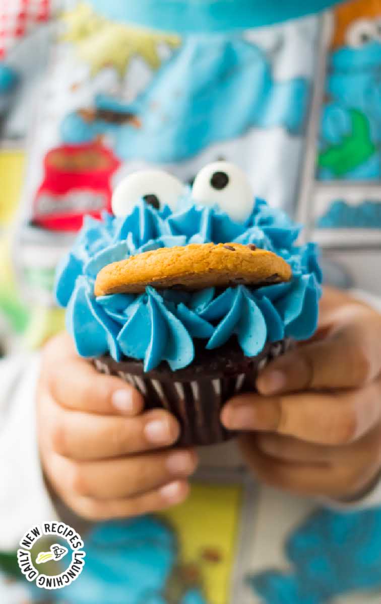 Cookie Monster Cupcakes with candy eyes and a cookie being held