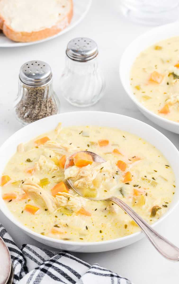 close up shot of a serving of Creamy Chicken and Rice Soup in a bowl with a spoon