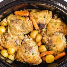 Overhead view of creamy crockpot chicken served over mashed potatoes with fresh parsley garnish.