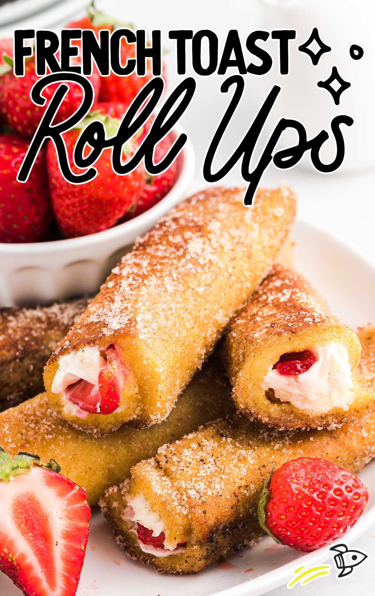 close up shot of French Toast Roll Ups with sliced strawberries on a plate
