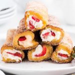 close up shot of French Toast Roll-Ups rolled in cinnamon sugar piled on a plate