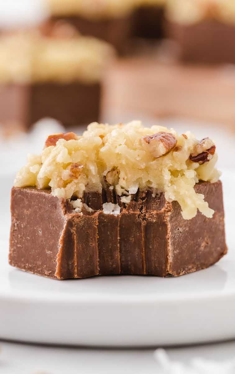 close up shot of German chocolate fudge topped with frosting and a bite taken out of fudge
