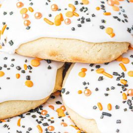 close up shot of Halloween Sugar Cookies topped with icing and sprinkles piled on a plate