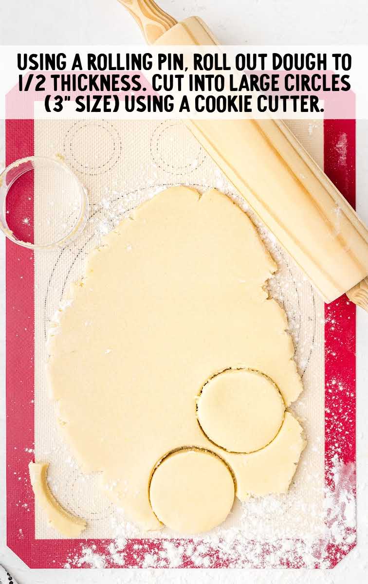 cookie dough being cut into large circles with a cookie cutter